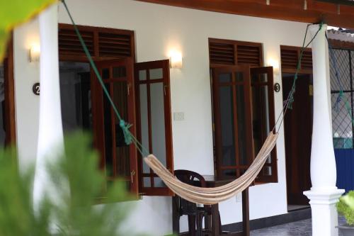 a hammock hanging outside of a house at Bakery Family Guest House in Mirissa