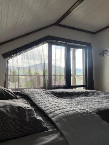 a bed in a room with a large window at Готельно-Ресторанний комплекс Кичера in Volovets