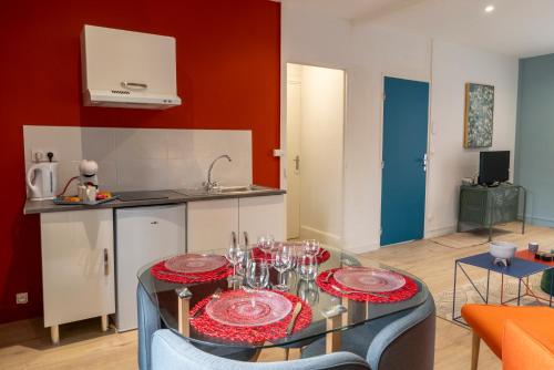 une cuisine avec une table avec des assiettes et des verres dessus dans l'établissement Oslo - Appartement Spacieux et Cosy, à Charleville-Mézières