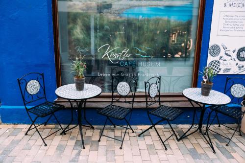 a group of tables and chairs in front of a store at Tor zur Altstadt in Husum