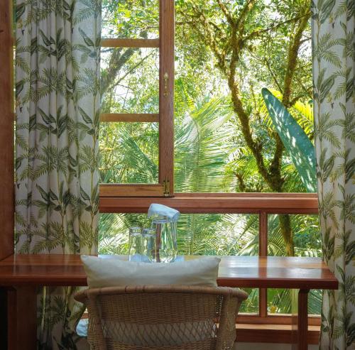 a window with a table in front of a window with a windowtaining at Casa de Vista Alta in Mindo