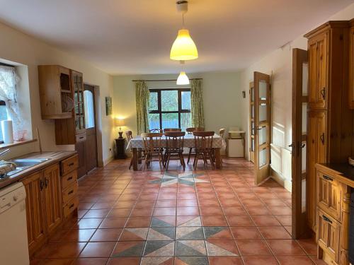 a kitchen with a table and a dining room at Letterfrack Farmhouse on equestrian farm in Letterfrack beside Connemara National Park in Tullywee Bridge