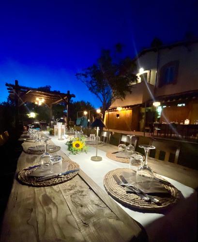 a long table with wine glasses on it at night at Casale Viridi - nel fresco delle colline Umbre in Narni
