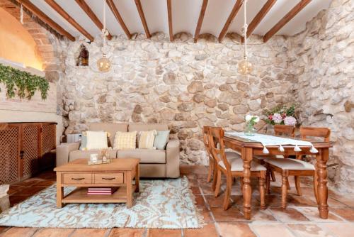 uma sala de estar com uma mesa e uma parede de pedra em Altea Suite Vault Casa autentica del Casco antiguo by Vero em Altea
