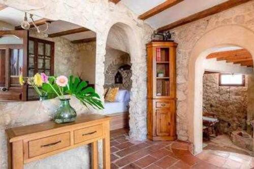 um quarto com uma mesa com um vaso de flores em Altea Suite Vault Casa autentica del Casco antiguo by Vero em Altea