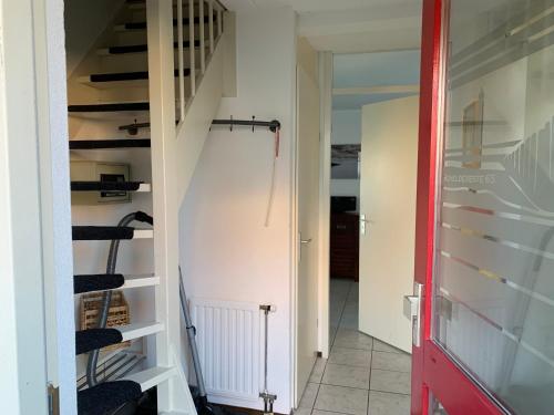 einen Flur mit einer Treppe und einer roten Tür in der Unterkunft Kustverhuur, Park Scheldeveste Zwin 065 in Breskens