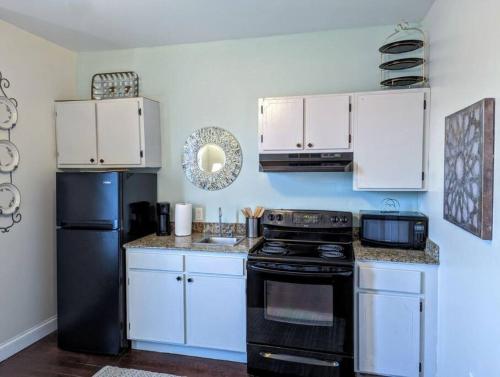 a kitchen with a black stove and white cabinets at Dunes Suite (Work Friendly) in Florence