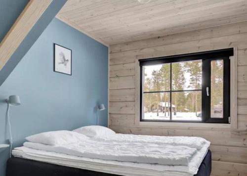 um quarto com uma cama grande e uma janela em Paritalomökki Välirakka em Kittilä