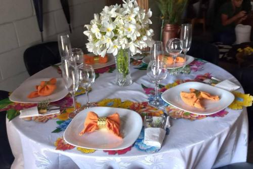 a table with plates of food and glasses and flowers at recanto do sossego. in Sinop