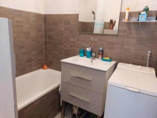 une salle de bain avec un lavabo et une baignoire dans l'établissement Bocca Baie T2 en bord de mer - Axelle Loc Appart, à Cannes