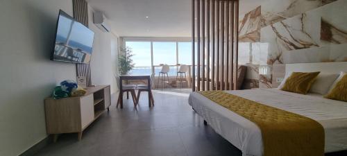 1 dormitorio con cama y vistas al océano en Principado Benidorm Suites Levante, en Benidorm