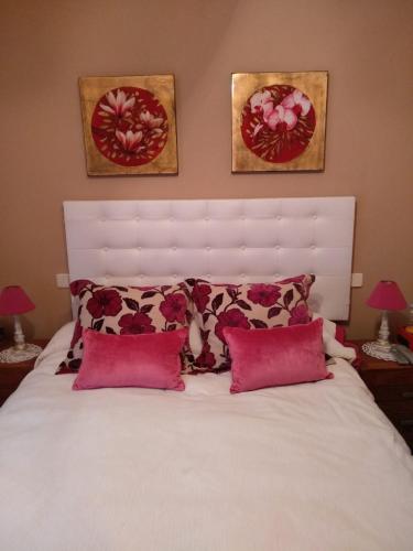 a bedroom with a white bed with red pillows at Zohet Santian in Arcones