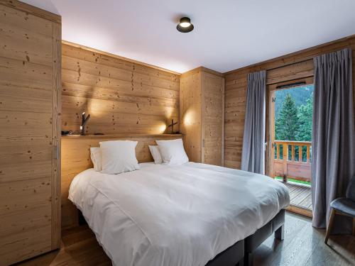 a bedroom with a large bed and a window at Appartement Courchevel 1650, 4 pièces, 6 personnes - FR-1-563-15 in Courchevel