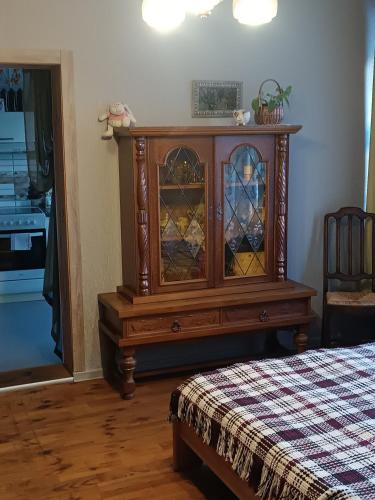 a wooden cabinet with stained glass windows in a bedroom at STĀRĶA APARTAMENTI in Kuldīga