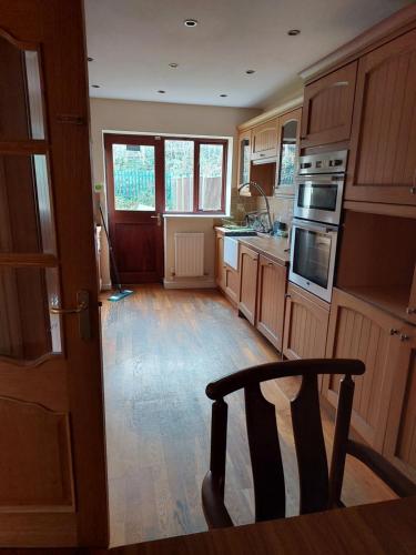 a kitchen with a wooden floor and a wooden chair at Dobcross Close in Manchester