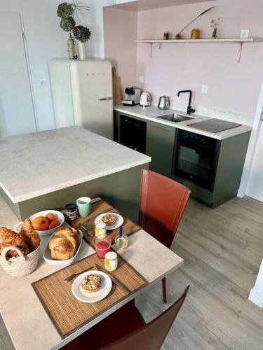 une cuisine avec une table et des assiettes de nourriture dans l'établissement Gwiskaou A 170m de la plage, à Concarneau