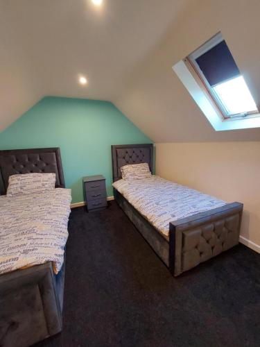 a bedroom with two beds and a skylight at Dobcross Close in Manchester