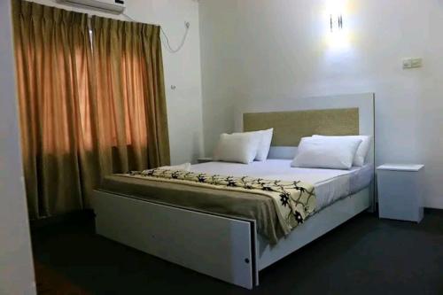 ein großes Bett in einem Zimmer mit Fenster in der Unterkunft Rochana Holiday Resort in Anuradhapura