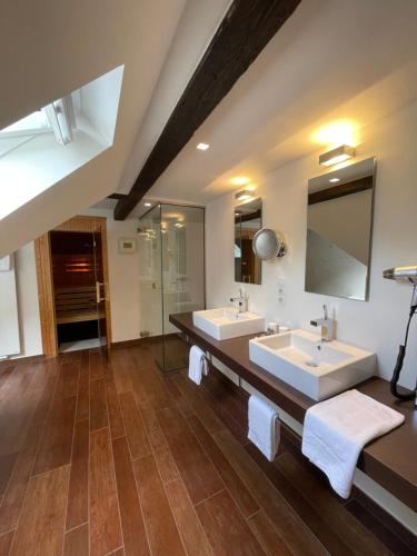 a bathroom with two sinks and a large mirror at Hotel Kieler Yacht-Club in Kiel
