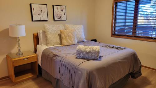 een slaapkamer met een bed, een lamp en een raam bij Cozy Flagstaff Condo in Flagstaff