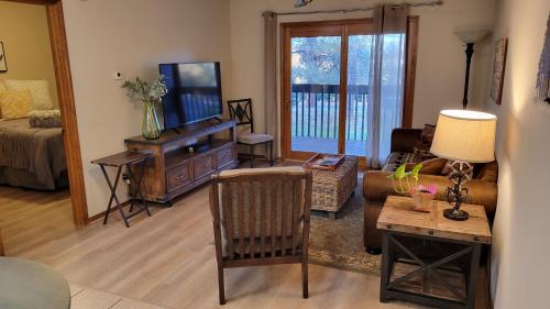 sala de estar con sofá y TV en Peaceful Flagstaff Condo, en Flagstaff