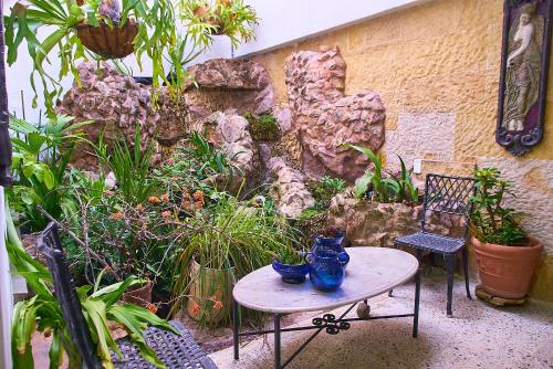 a garden with a table and chairs and plants at Hotel Boutique Fiorentina Medellín in Medellín