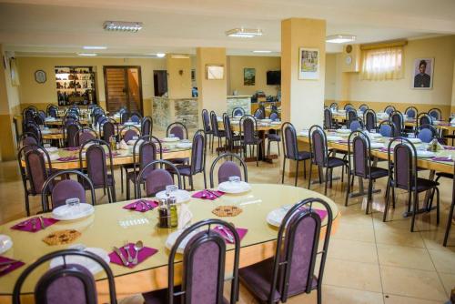 - une salle à manger avec des tables, des chaises et des serviettes roses dans l'établissement Hotel BARBARIC, à Međugorje