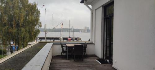 a balcony with a table and a view of the water at Hotel Kieler Yacht-Club in Kiel