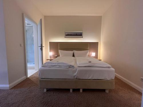 a bedroom with a large bed with two lamps at Hotel Kieler Yacht-Club in Kiel