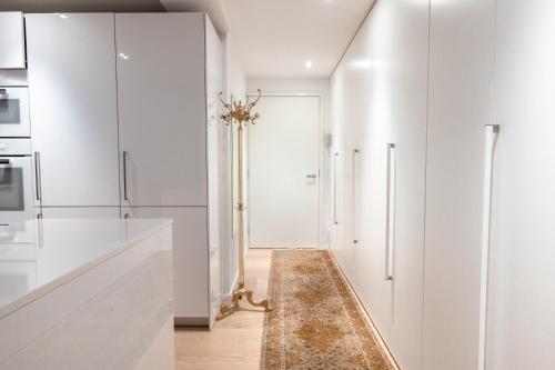 una cocina con armarios blancos y una alfombra en el suelo en 2ndhomes Gorgeous and Modern 2BR Apartment with Balcony, en Helsinki
