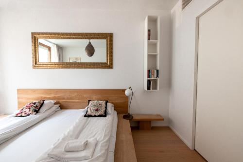 2ndhomes Gorgeous and Modern 2BR Apartment with Balcony في هلسنكي: غرفة نوم بسريرين ومرآة على الحائط