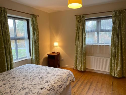 1 dormitorio con 1 cama y 2 ventanas grandes en BunkHouse - Letterfrack Farm, en Letterfrack