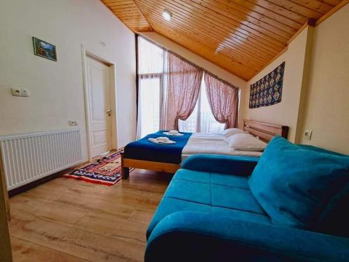 ein Schlafzimmer mit einem Bett, einem Sofa und einem Fenster in der Unterkunft Cottage in Gudauri in Gudauri