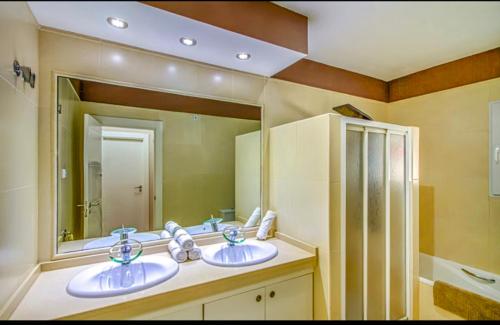 a bathroom with two sinks and a large mirror at Villa Veneziola La Manga in Murcia