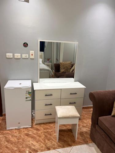 uma sala de estar com uma cómoda branca e um espelho em شقة الغامدي em Al Jāmi‘ah