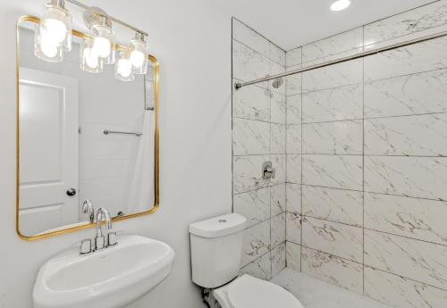 a bathroom with a toilet and a sink and a mirror at Studios on Fourth in McAllen