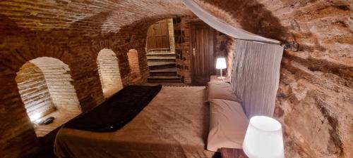 a bedroom with a bed in a stone wall at Cueva árabe en el casco antiguo, Toledo in Toledo