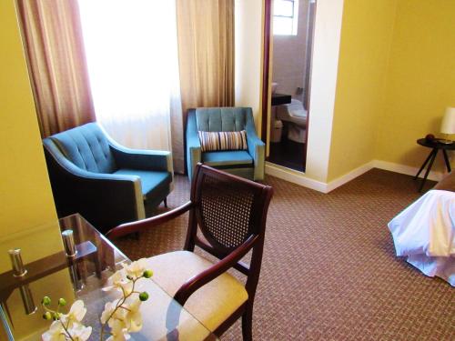a hotel room with chairs and a table and a mirror at Los Leones Hotel Boutique in Arequipa