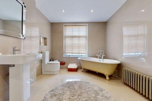 a large bathroom with a tub and a sink at City Central Georgian House with Parking in Liverpool