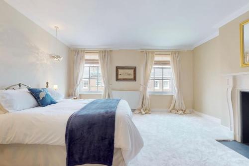 a white bedroom with a large bed and windows at City Central Georgian House with Parking in Liverpool