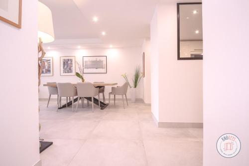une salle à manger avec des murs blancs, une table et des chaises dans l'établissement Appartement Céto Superb and luminous apartment, à Cannes