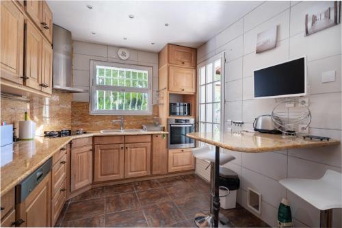 une cuisine avec des armoires en bois et un comptoir dans l'établissement Villa Caroubiers Pretty provençal villa with swimming pool, à Mougins