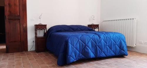 a blue bed with a blue comforter in a room at Locanda di Posta in Camarda