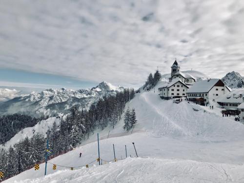 un lodge de ski au sommet d'une montagne enneigée dans l'établissement Mountain Apartment Rododendro, à Tarvisio