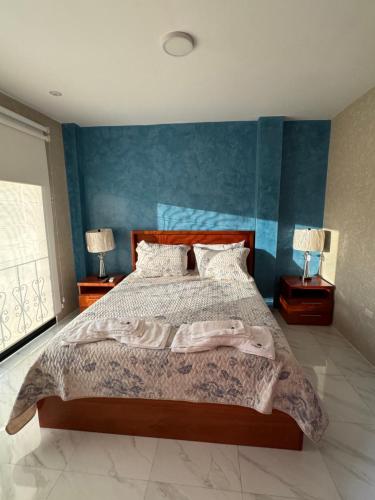 een slaapkamer met een groot bed en 2 lampen op tafels bij GALASUITES in Puerto Baquerizo Moreno