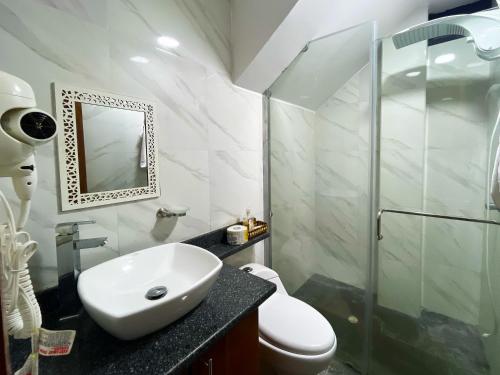 een witte badkamer met een wastafel en een douche bij GALASUITES in Puerto Baquerizo Moreno