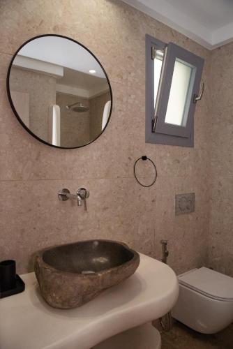 a bathroom with a bowl sink and a mirror at Anais Of Naxos in Agia Anna Naxos
