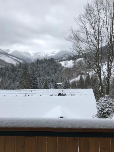 a snow covered roof of a house with mountains in the background at Chata Soňa in Terchová