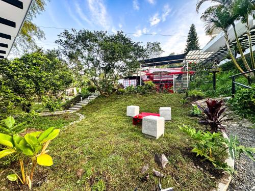 a garden with a red table and white benches at Tierra Maravilla in Salento