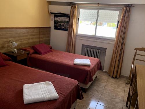 a hotel room with two beds and a window at Hotel Rossetti y Spa in Mina Clavero